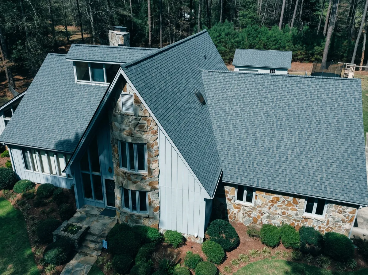 Gray architectural shingle roof on a stone and white chalet-style home — roofing near Dudley, NC